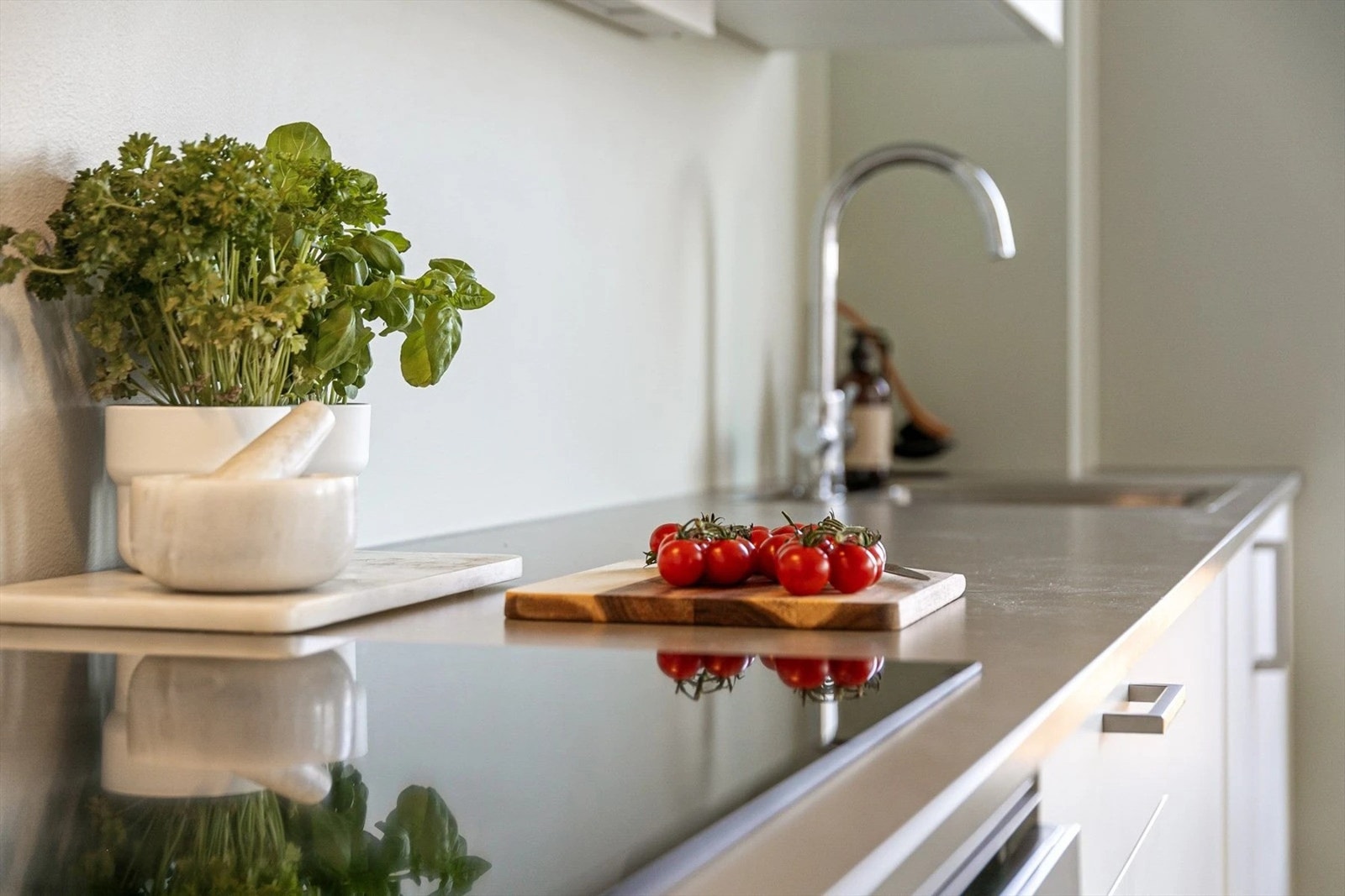 Innredning fra Sigdal fra 2024 med skuffer og skap med hvite, glatte fronter fronter og grå benkeplate av laminat. Galleribilde