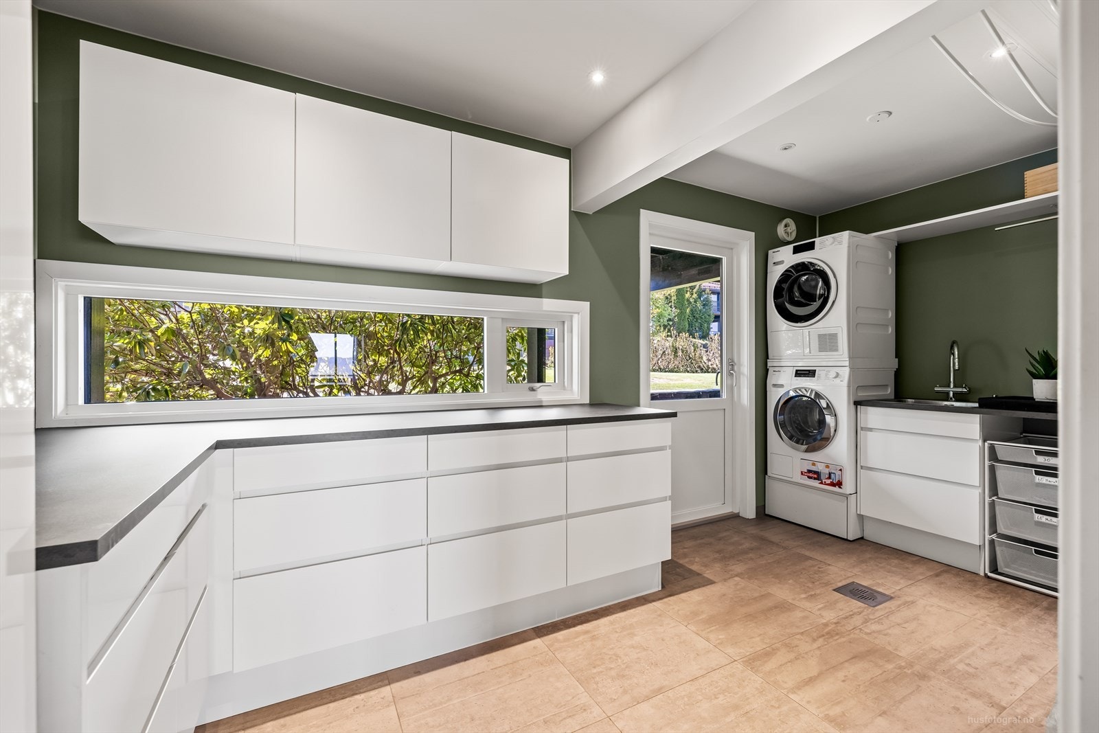 Det er praktisk grovkjøkken/vaskerom i tilknytning til kjøkkenet. Det er vannbåren gulvvarme og innredning med nedfelt skyllekar og opplegg til vaskemaskin og tørketrommel Galleribilde