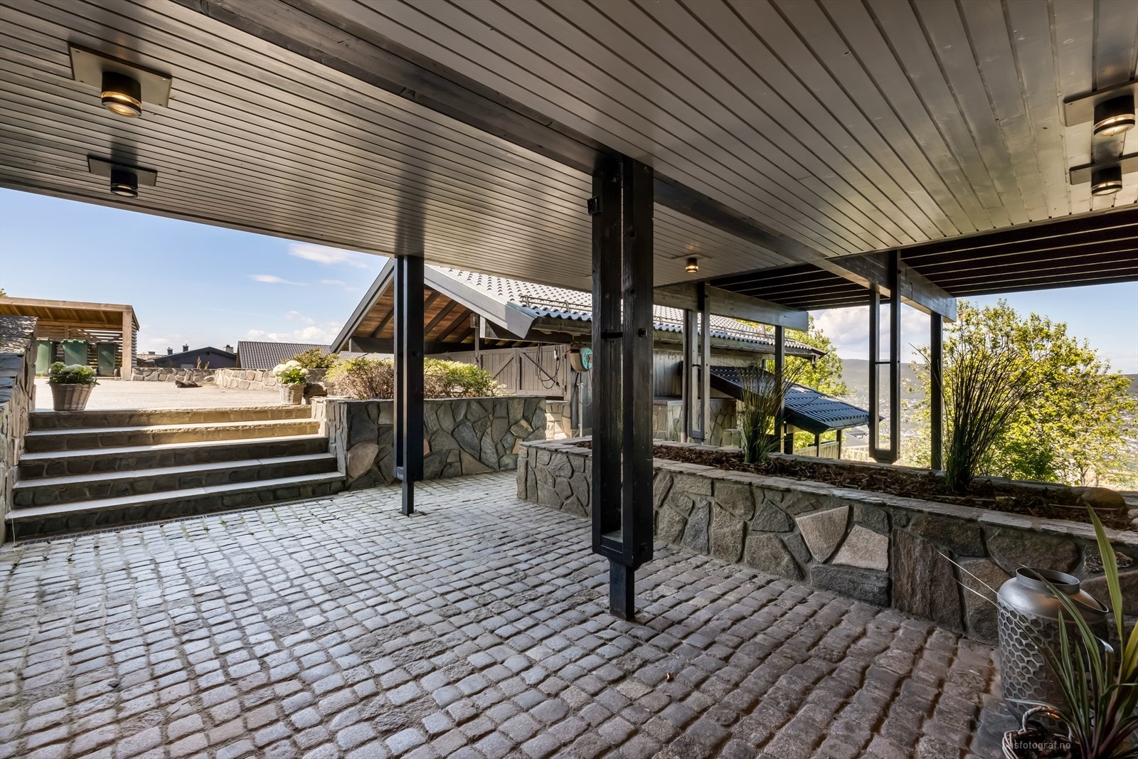 Det er lagt smågatestein foran inngangsparti og murer som er pent forblendet med naturstein Galleribilde