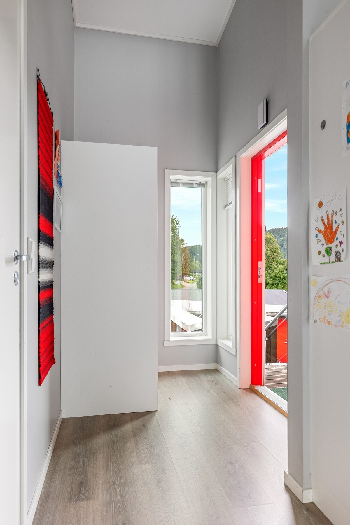 Velkommen inn | Førsteinntrykket er en lys entré med plass for å henge av seg yttertøyet i skyvedørsgarderobe Galleribilde