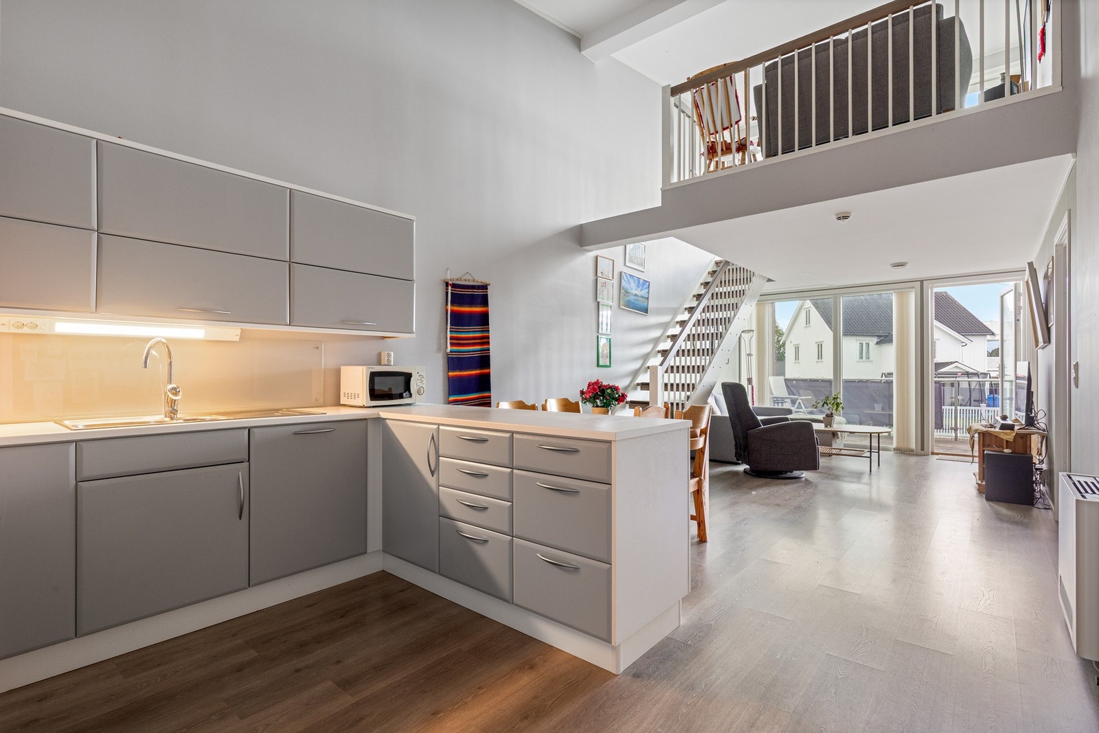 De store vindusflatene og den gode takhøyden gir boligen en naturlig lys og luftig atmosfære Galleribilde