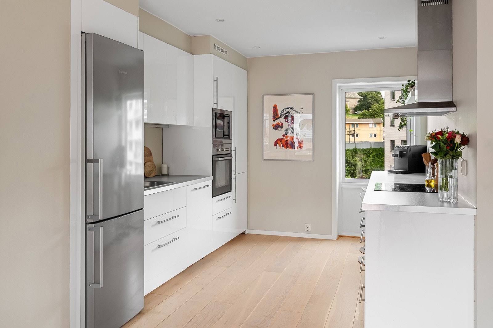 Kjøkkenet ble pusset opp i 2017 og har en stilren innredning med glatte fronter og benkeplate i laminat Galleribilde