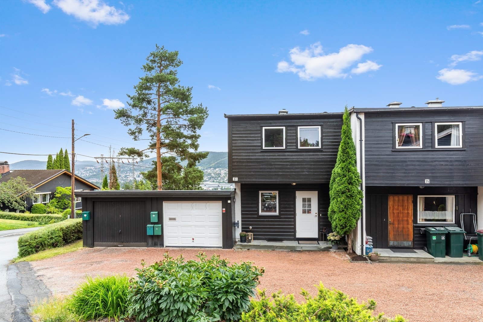 Boligen har enkel adkomst med garasje rett utenfor døren, samt usjenert hage og solrike terrasser Galleribilde