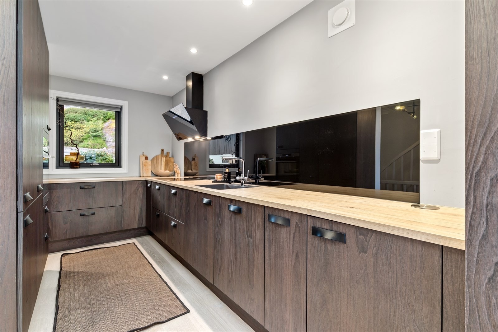 Kjøkkenet har glatte fronter, godt med benkeplass og integrerte hvitevarer Galleribilde