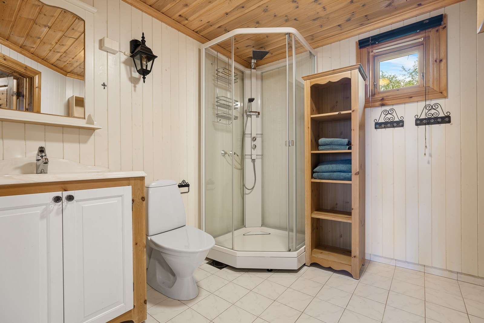 Badet har flislagt gulv med elektriske varmekabler som gir en behagelig varme. Innredningen består av nedfelt servant, toalett og dusjkabinett Galleribilde