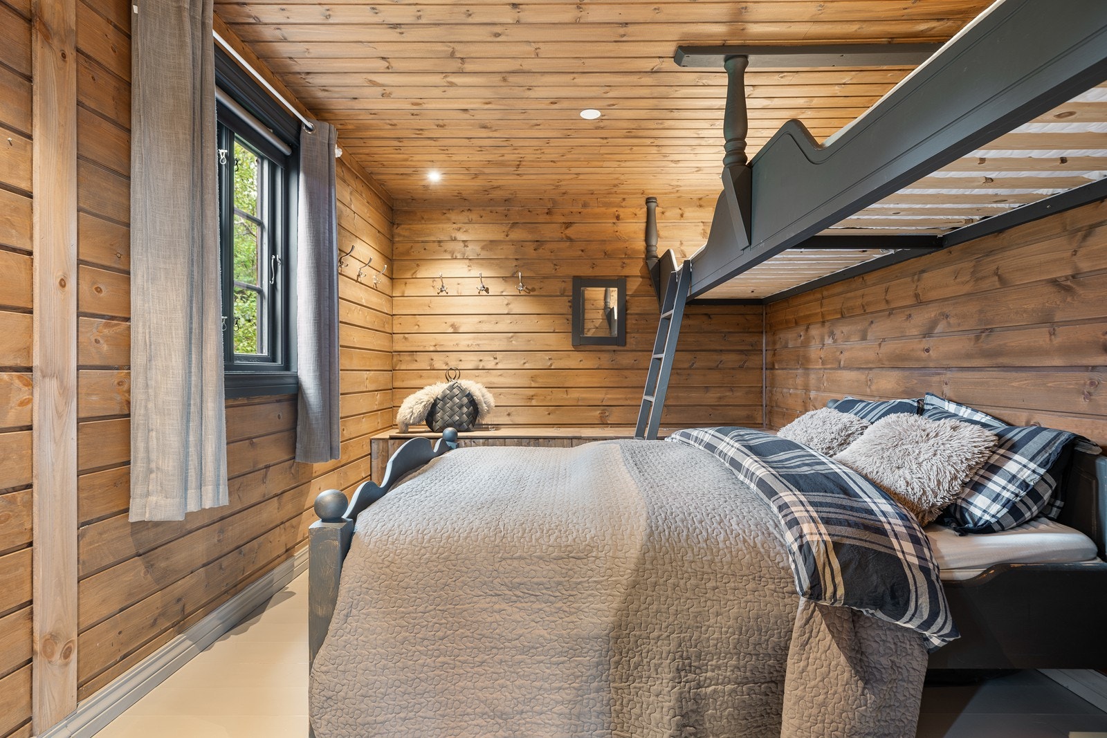 Soverom 4 er romslig, med plass til dobbeltseng og hems. Store vinduer slipper inn rikelig med naturlig lys, noe som gir en lys og luftig atmosfære Galleribilde