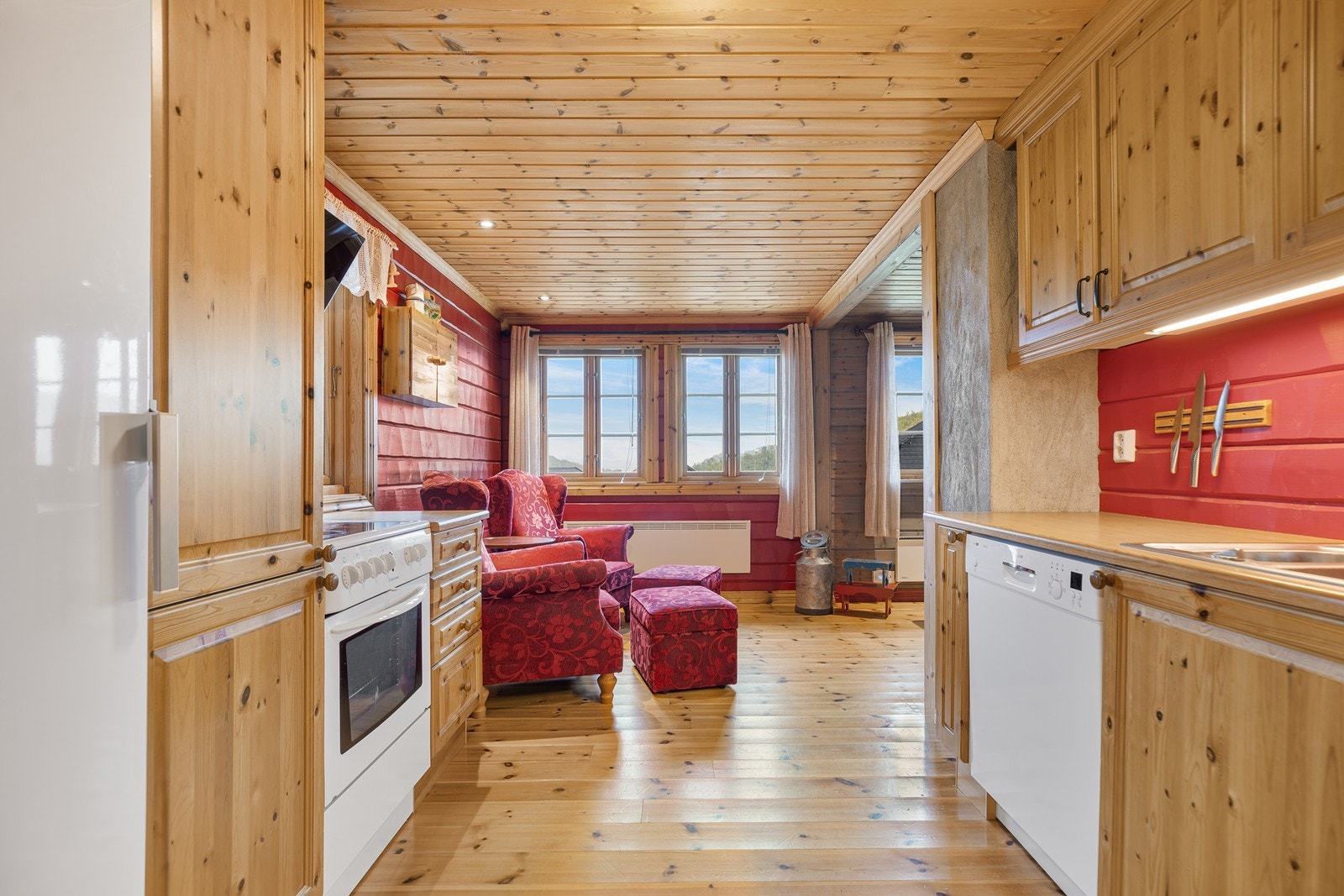 Kjøkkenet er innredet med profilerte fronter og benkeplate av laminat. Store vindusflater gir godt innslipp av naturlig lys og bidrar til en luftig og trivelig romfølelse Galleribilde