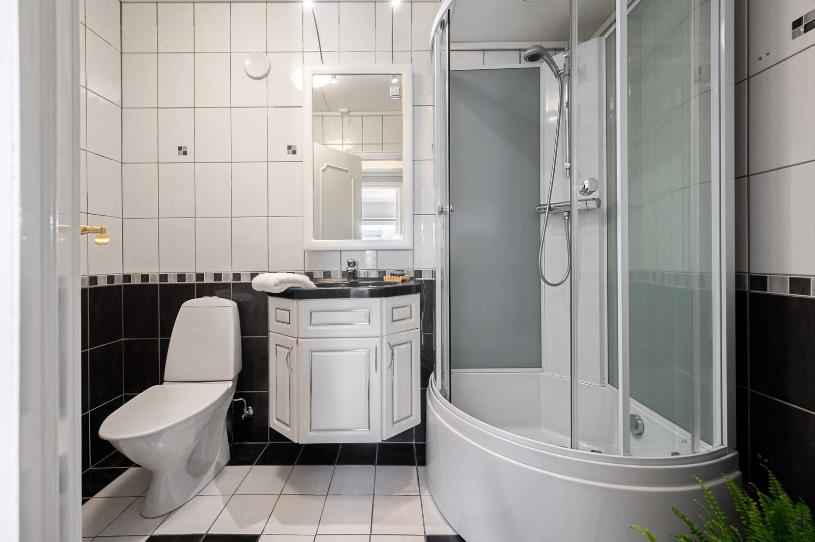 Helfliset bad med dusjkabinett, wc og servant med innredning. Galleribilde