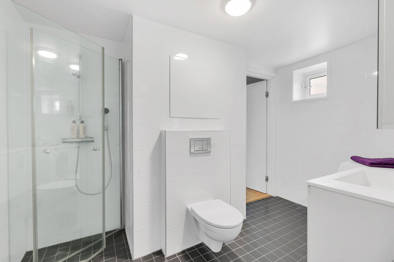 Flislagt bad med gulvvarme og opplegg for vaskemaskin. Galleribilde