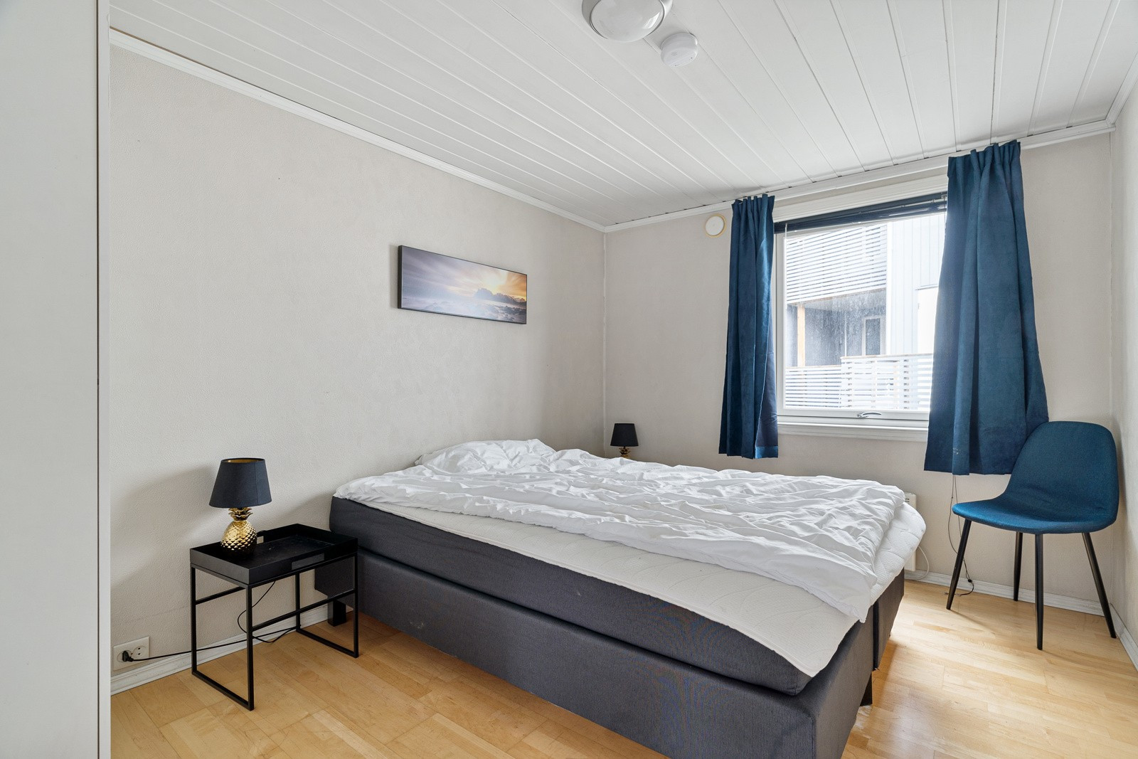 Romslig soverom med plass til stor seng og tilhørende nattbord.