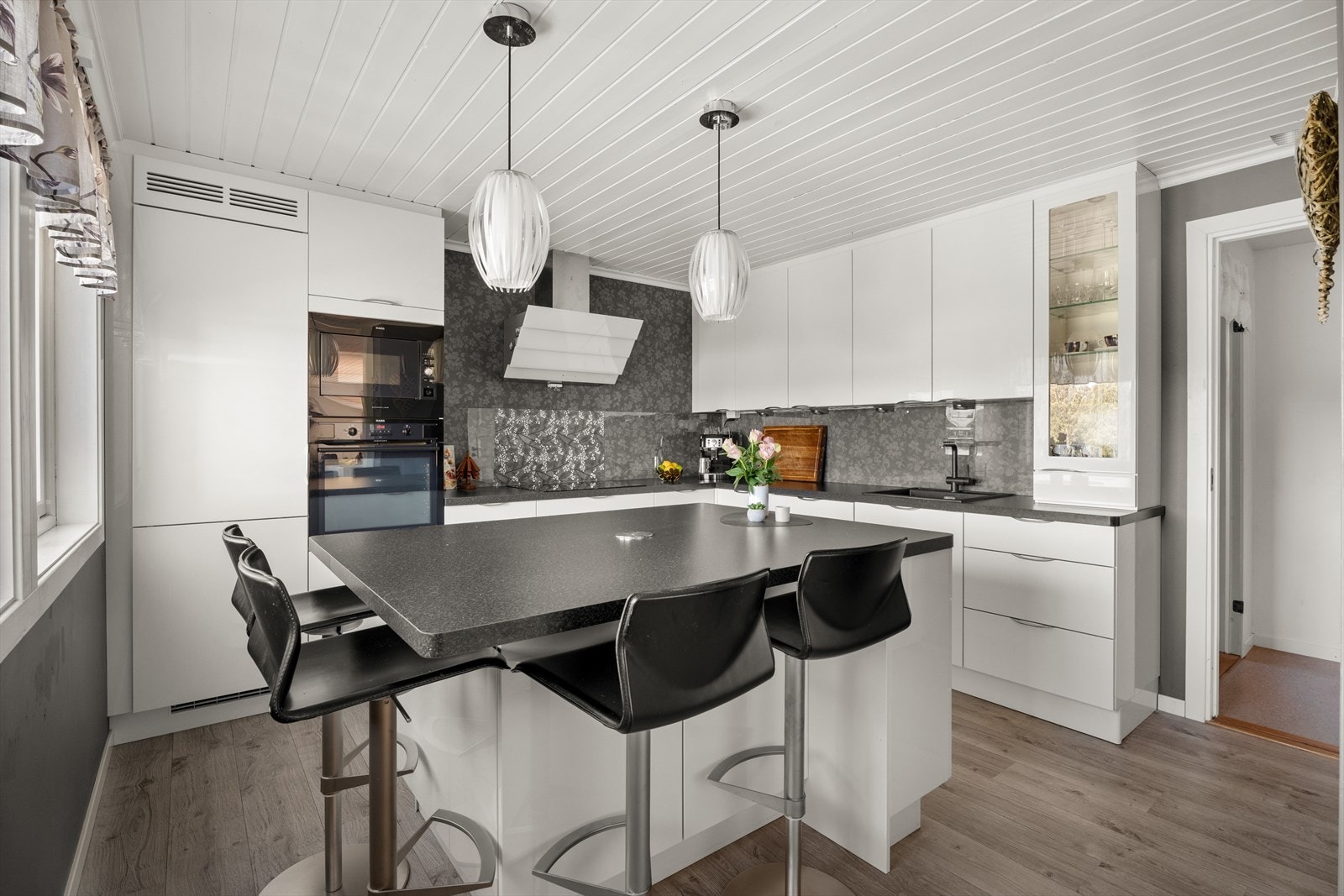 Kjøkkenet er utstyrt med en funksjonell kjøkkenøy som både bidrar med ekstra oppbevaringsplass og arbeidsflate, samtidig som den gir mulighet for sitteplasser. Øya fungerer også som et praktisk spisebord til for eksempel frokost eller hverdagsmiddager Galleribilde