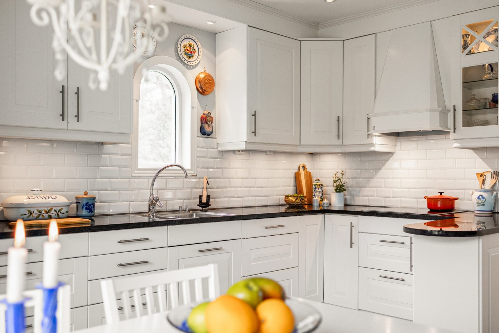 Lyst og romslig kjøkken med hvit, profilert innredning. Galleribilde