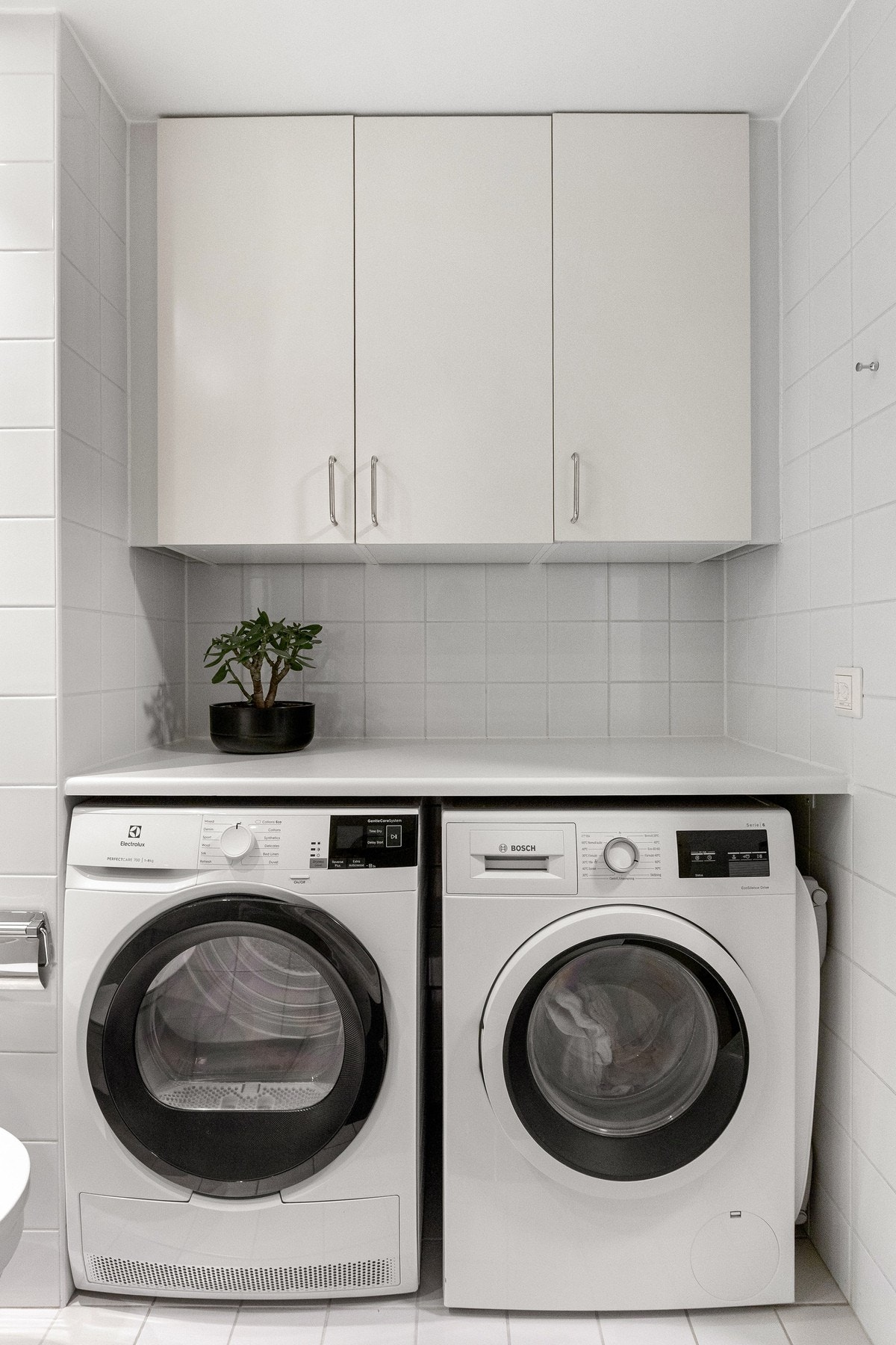 Utstyrt med vegghengt toalett, servant, innfliset speil, veggskap, lukket dusjhjørne med skyvedør og opplegg for vaskemaskin. Galleribilde