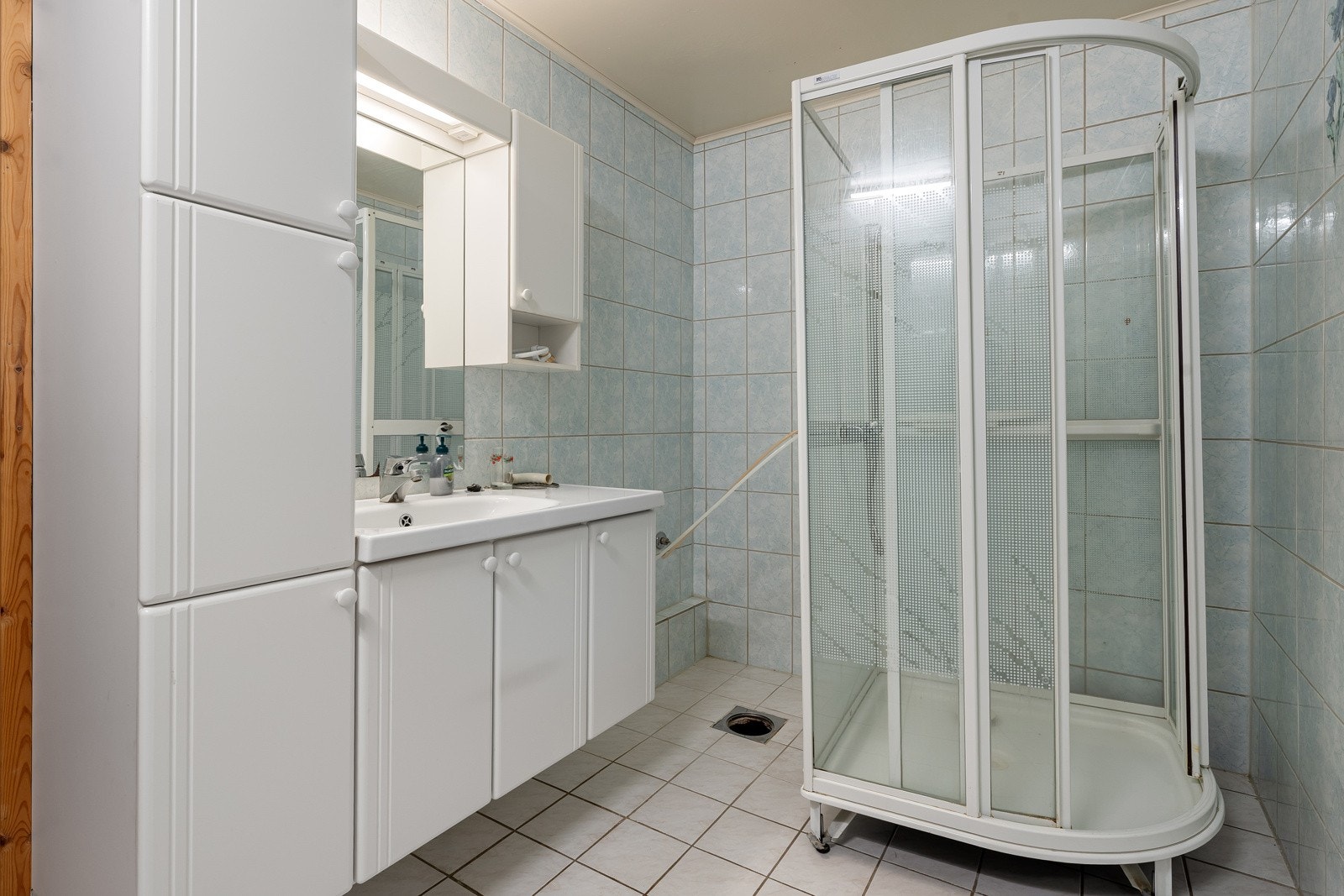 Baderom med stor innredning for lagring av baderomsartikler og dusjkabinett. I tillegg er det separat vaskerom og wc-rom. Galleribilde