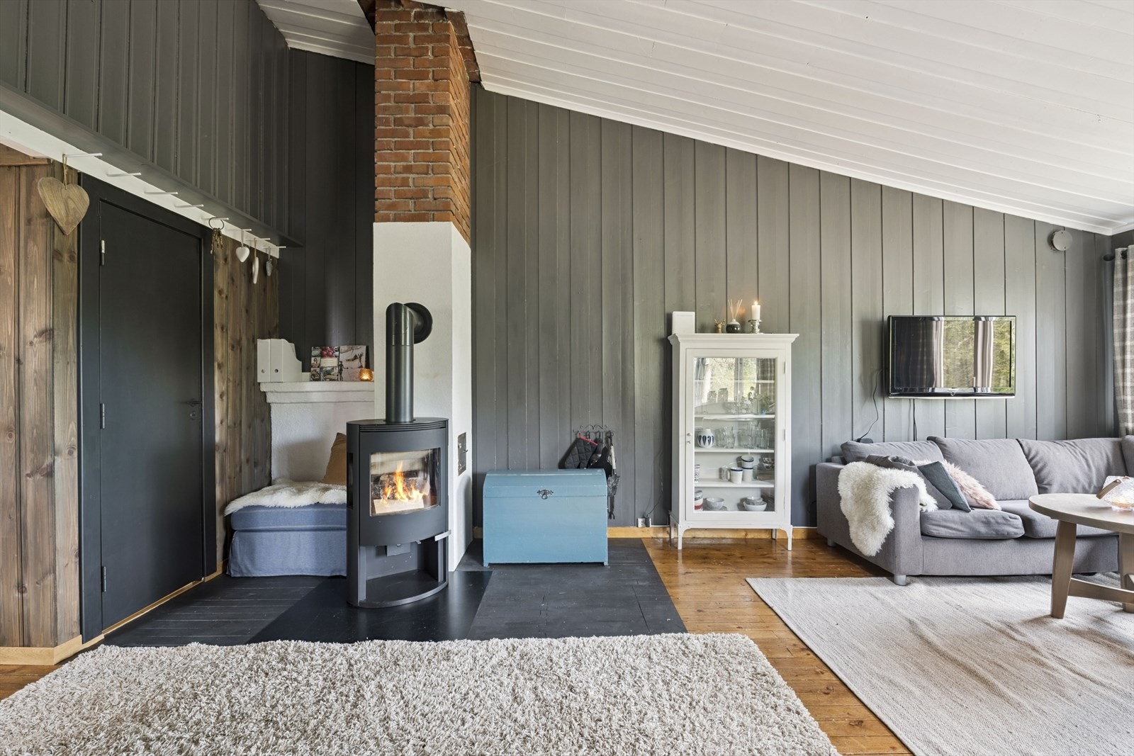 Lys og luftig stue med peisovn sentralt plassert i rommet Galleribilde