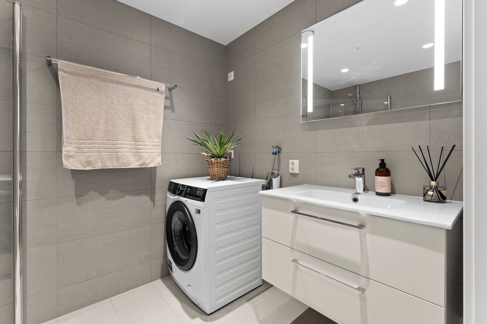 Begge badene har et lekkert og stilfullt preg med fliser på både vegger og gulv, downlights og varmekabler. Galleribilde