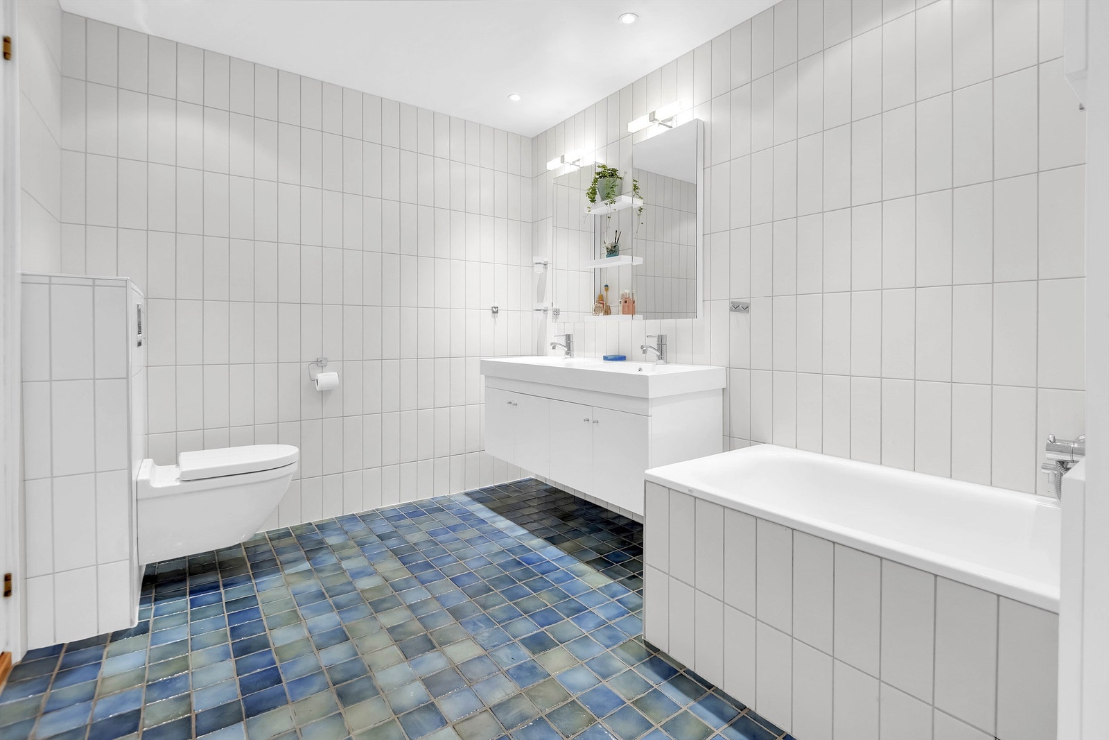 Baderom fra 2008 i følge eier med flislagte vegger og malt himling med downlights. Innredning med 2stk servant og 1-greps blandebatterier, speil og belysning på vegg over servant Galleribilde