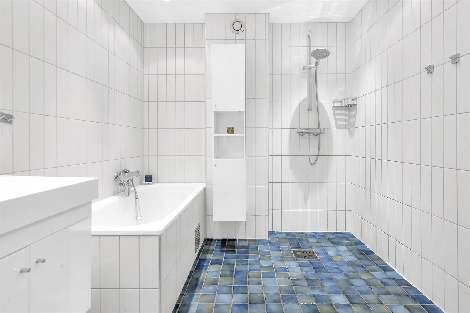 Det er dusjhjørne med hånddusj, og innmurt badekar med luftespalte og inspeksjonsluke. Galleribilde