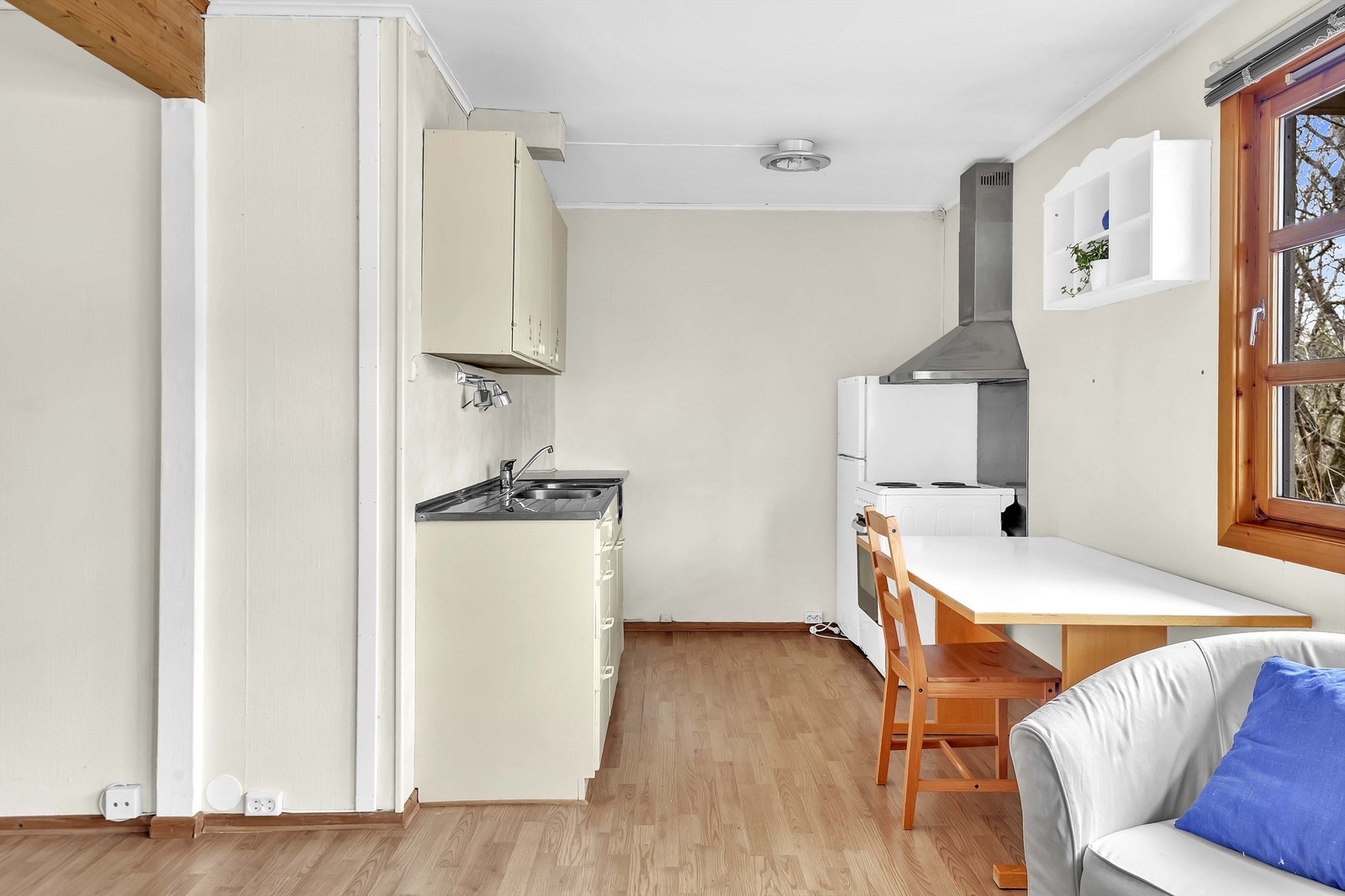 Hybelkjøkken med slette skapfronter og benkebeslag i stål med et-greps blandebatteri. Det er komfyr og ventilator med avtrekk ut, kjøleskap og vannrør i kobber, og avløp i plast. Galleribilde