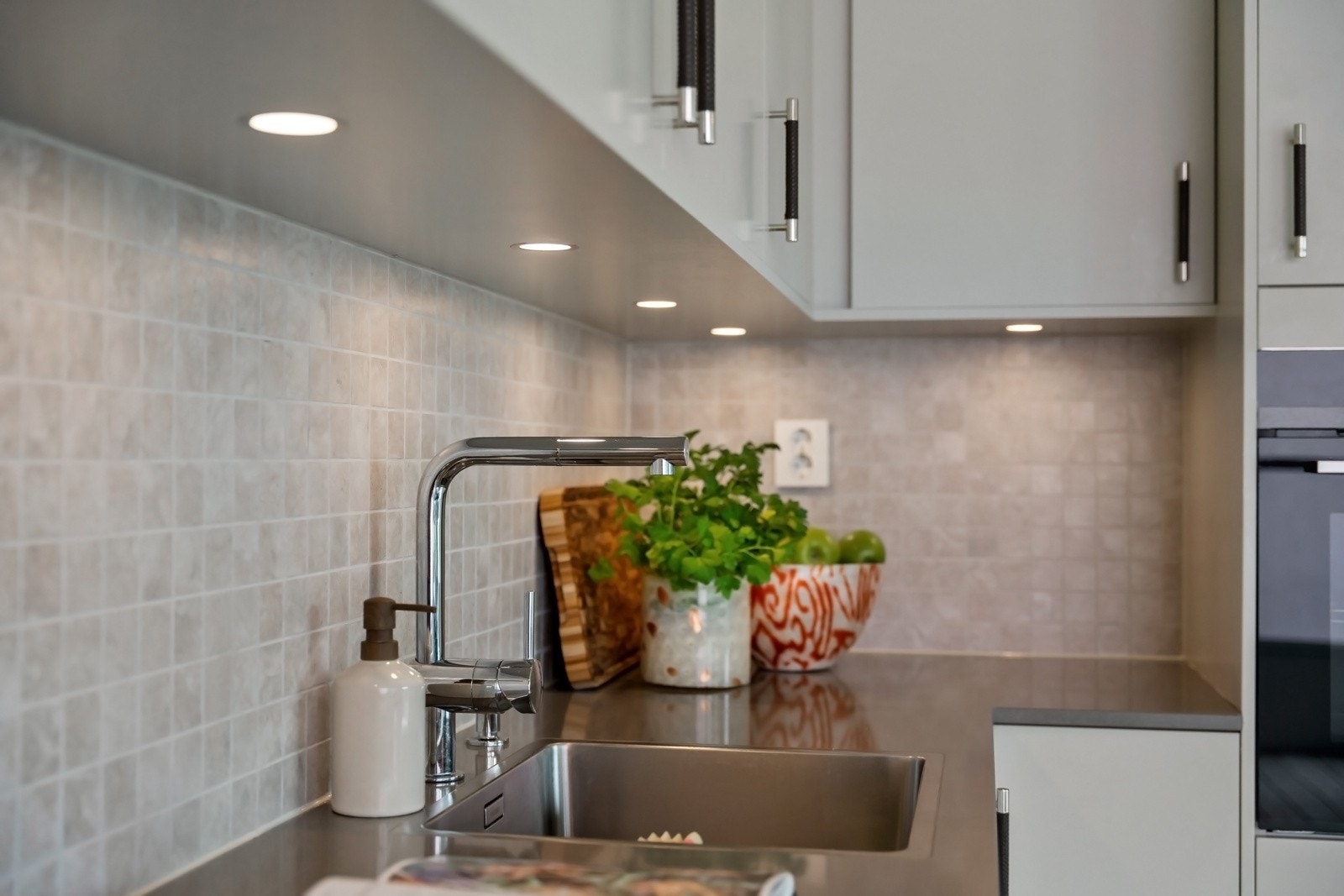 Over kjøkkenbenken er det lagt nye fliser, og det er montert lys under overskap og stikkontakter på vegg. Galleribilde