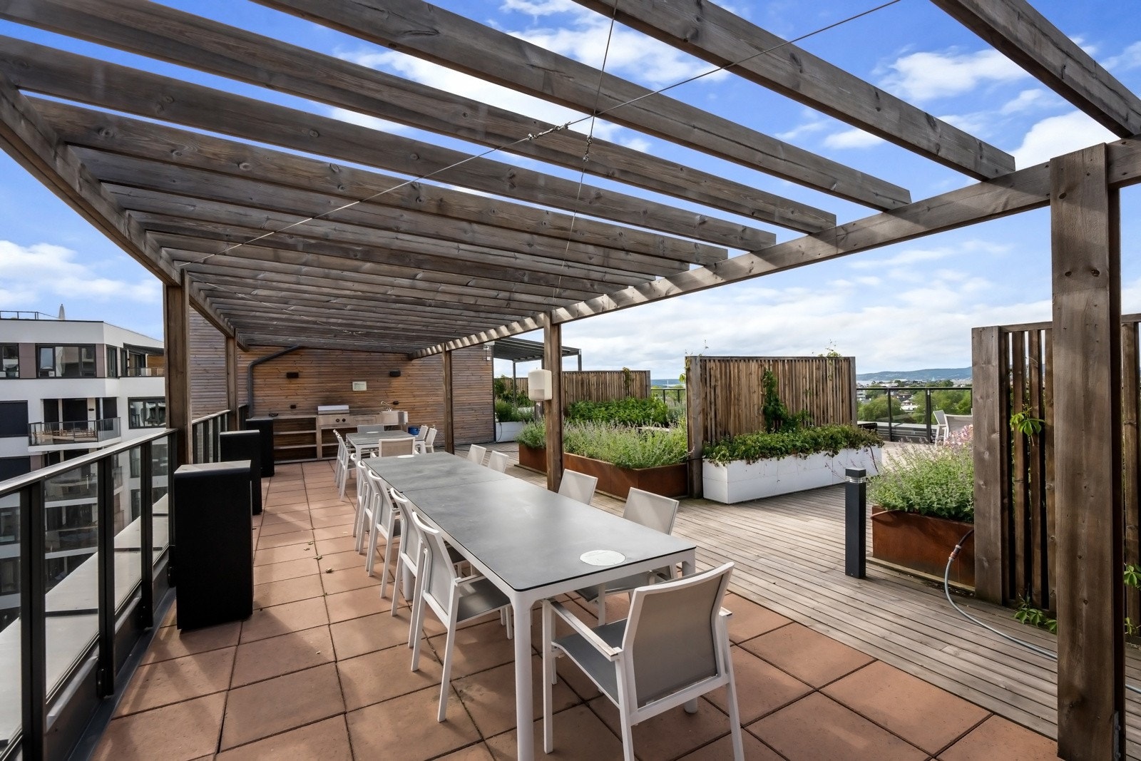 Utekjøkken/grill med tilhørende langbord. Galleribilde