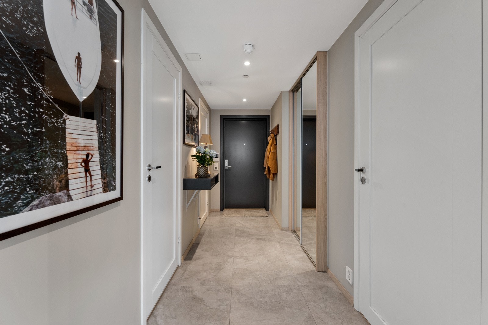 Leilighetens entré er romslig og innbyende. Nye fliser med gulvvarme, samt downlights i taket. Galleribilde