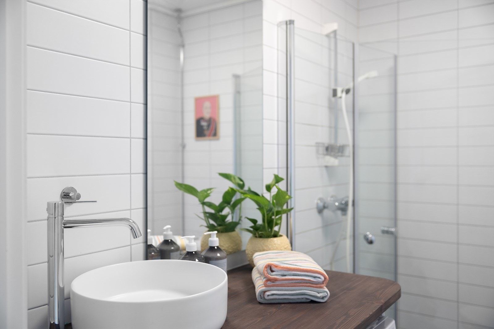 Badet består av gulvstående toalett, dusjplass med inn-utadslående dusjvegger og servant med ettgreps blandebatteri i innredning. Galleribilde