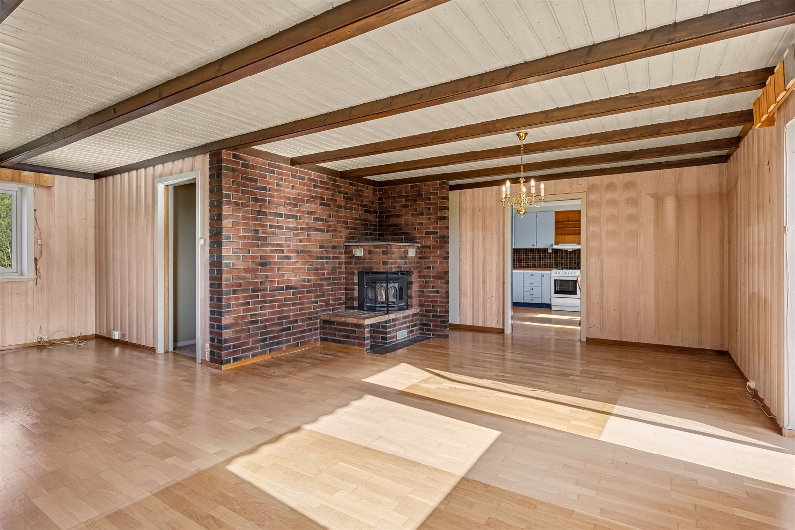 Sjarmerende stue med peis og panelvegger - et rom med varme og karakter. Galleribilde