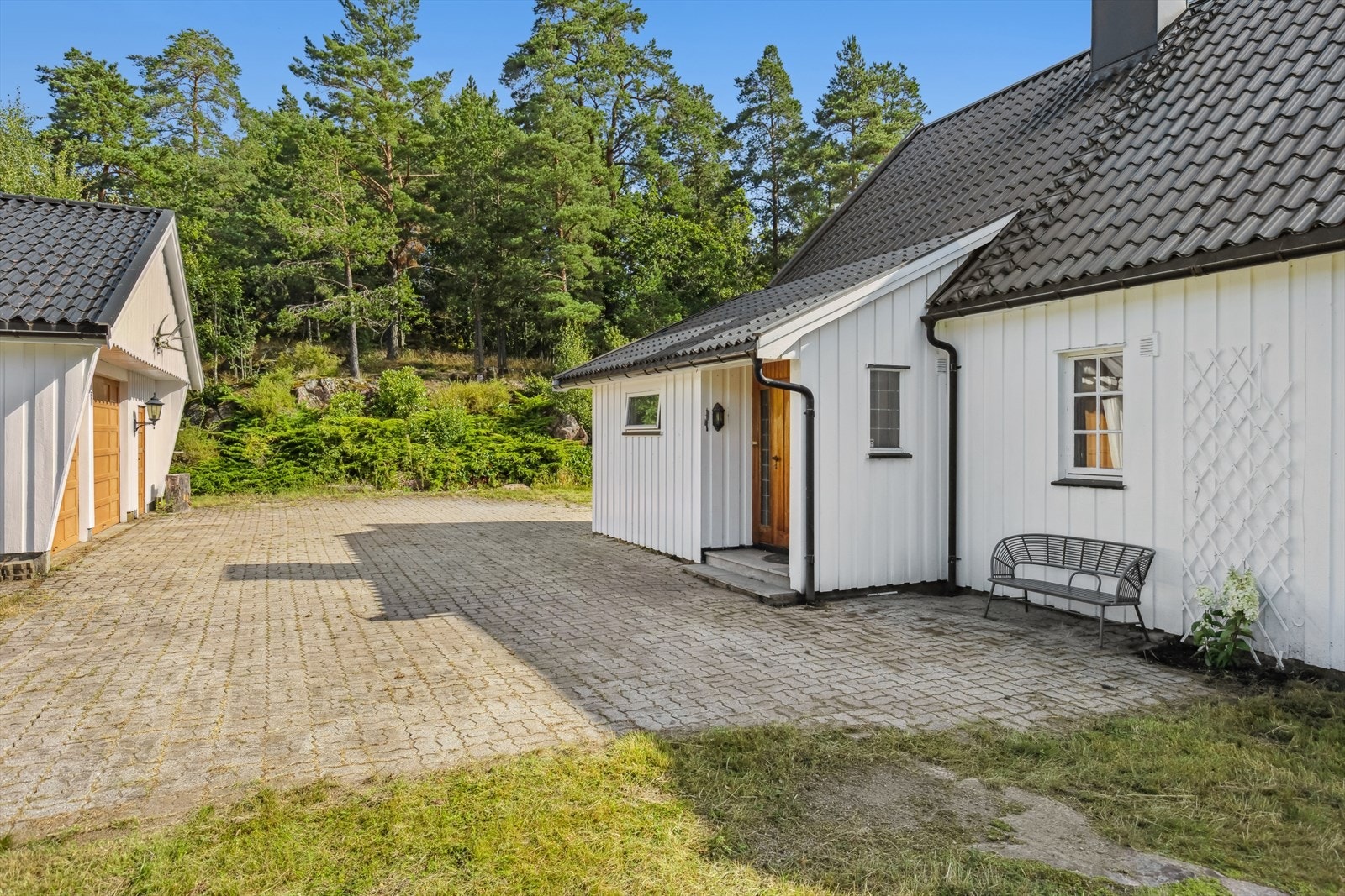 I dobbeltgarasje med bod og steinbelagt gårdsplass er det gode muligheter for parkering. Galleribilde