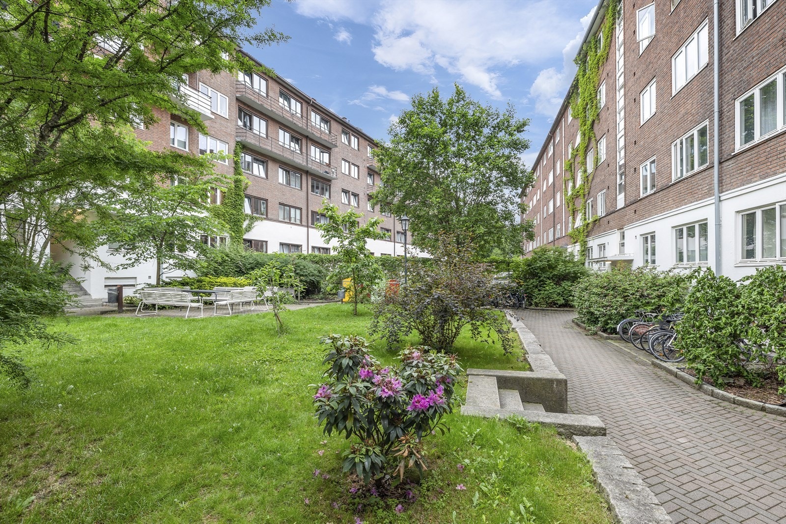 Lukket felles bakgård som er pent opparbeidet og er skjermet av høye porter. Galleribilde