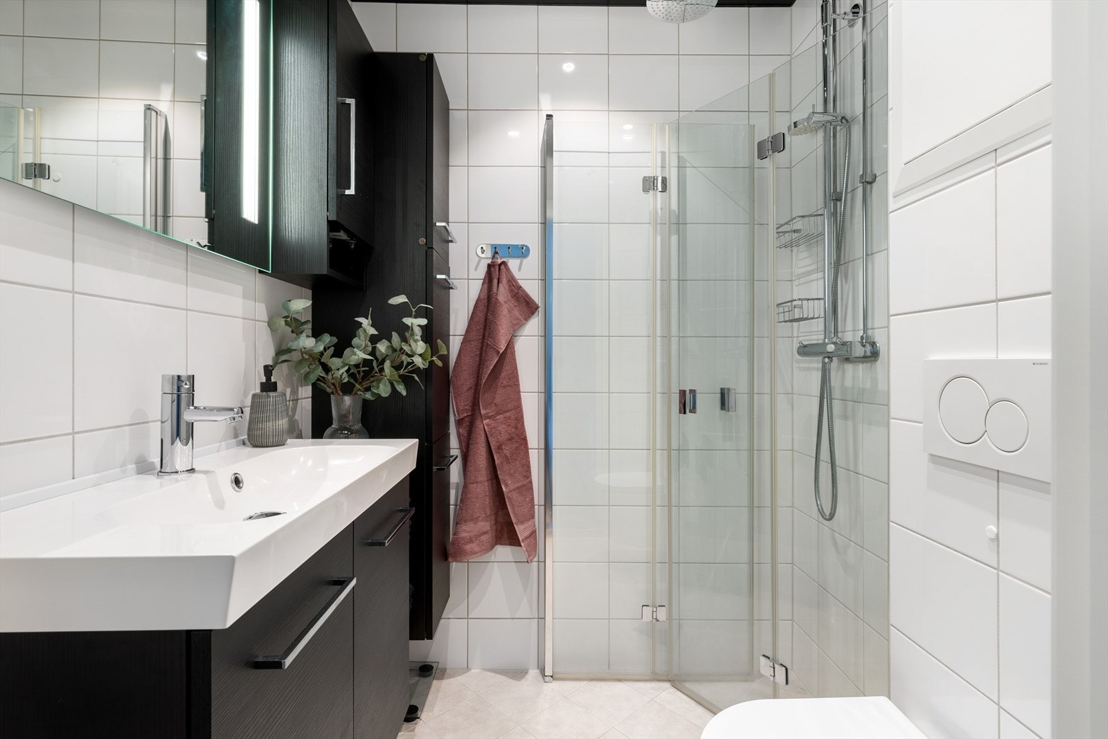 Pent flislagt bad fra 2017 med moderne og tidløse materialvalg. Veggene er belagt med fliser, taket er malt, og gulvet er flislagt med behagelige varmekabler for økt komfort. Galleribilde