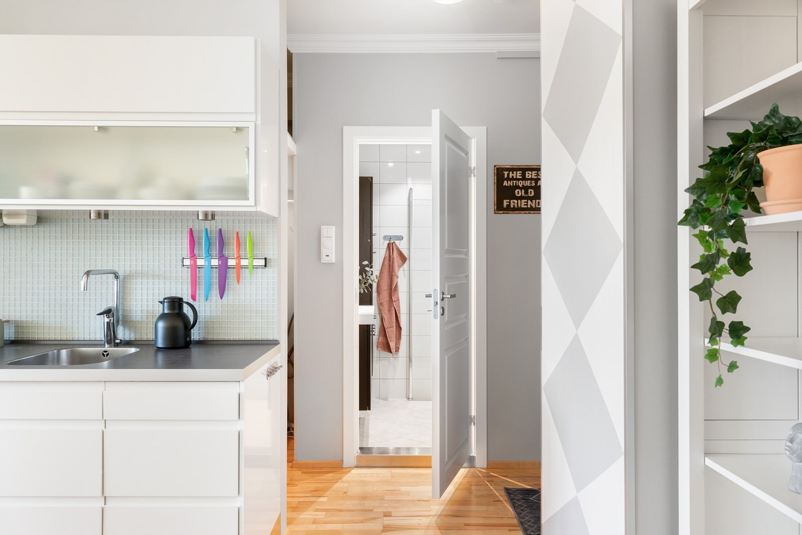 Over benkeplaten er det montert dekorative mosaikkfliser i glass, og det er belysning under overskapene som gir både funksjonelt og stemningsfullt lys. Galleribilde