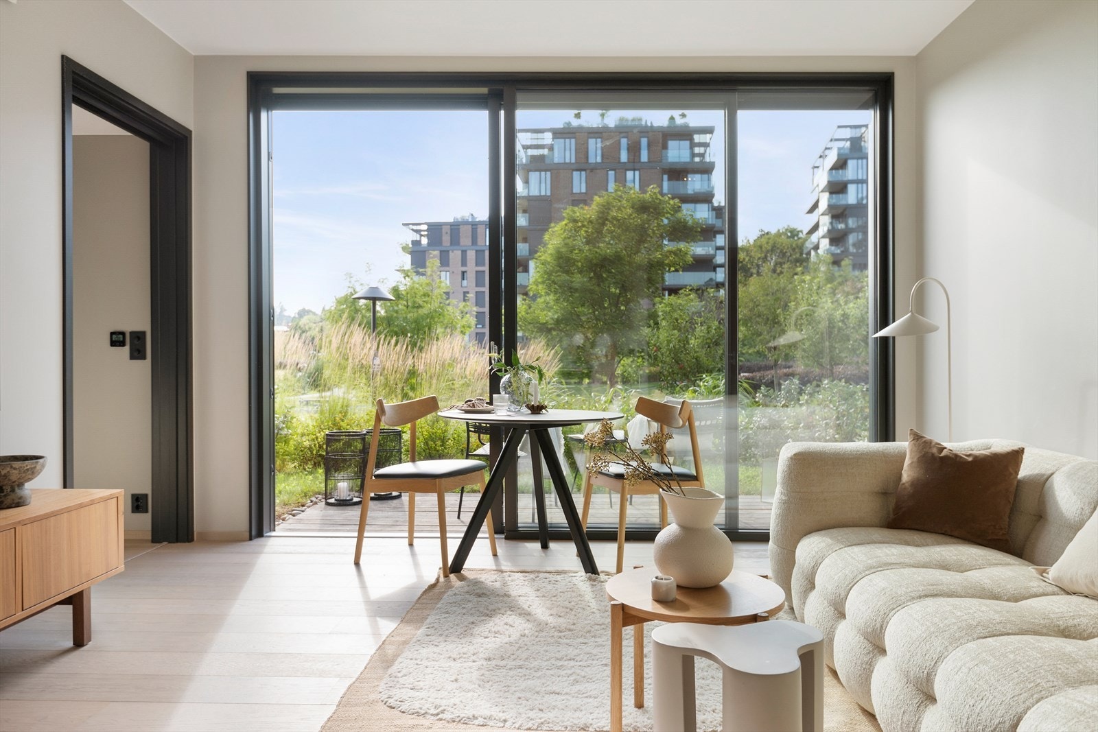 Lyst og solfylt med store skyvedører og nydelig utsikt mot terrasse og sameiets vakre park Galleribilde