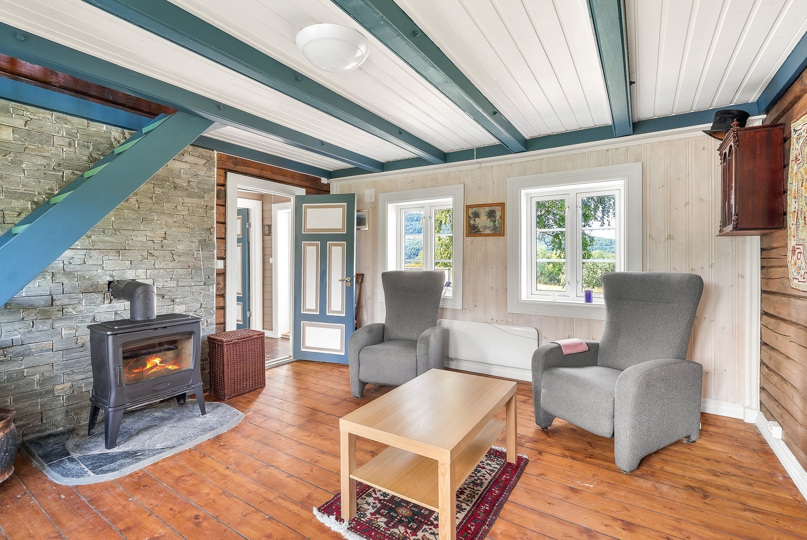 Lyst og innbydende oppholdsrom med flott peis, som gir både varme og atmosfære på kjølige dager. Galleribilde