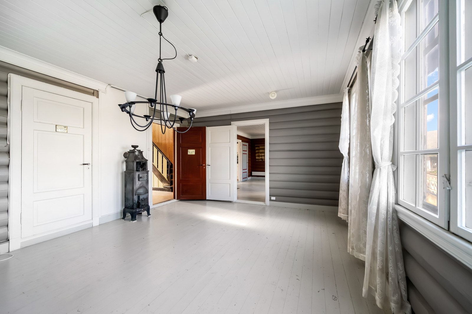 Stuene har malt tregulv og malte tømmervegger. Galleribilde