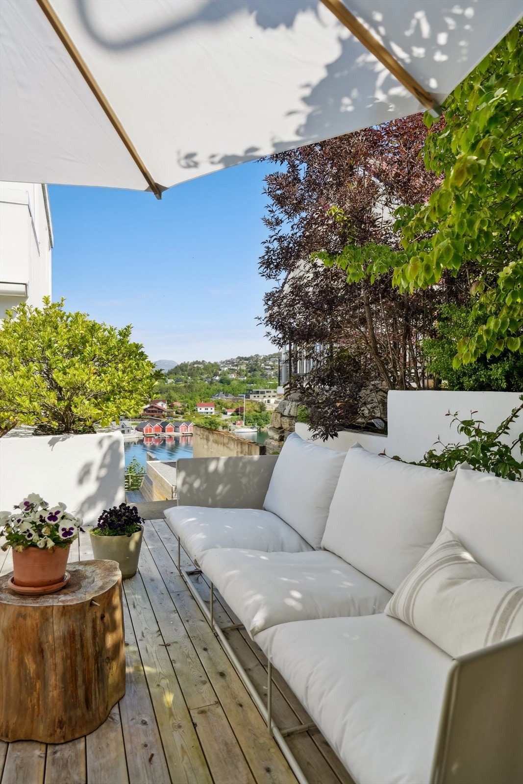 Terrassen mot syd har flere soner og sitteplasser. Det er trapp til underetasjen langs husets fasade mot øst. Her er det også idyllisk utsikt Galleribilde