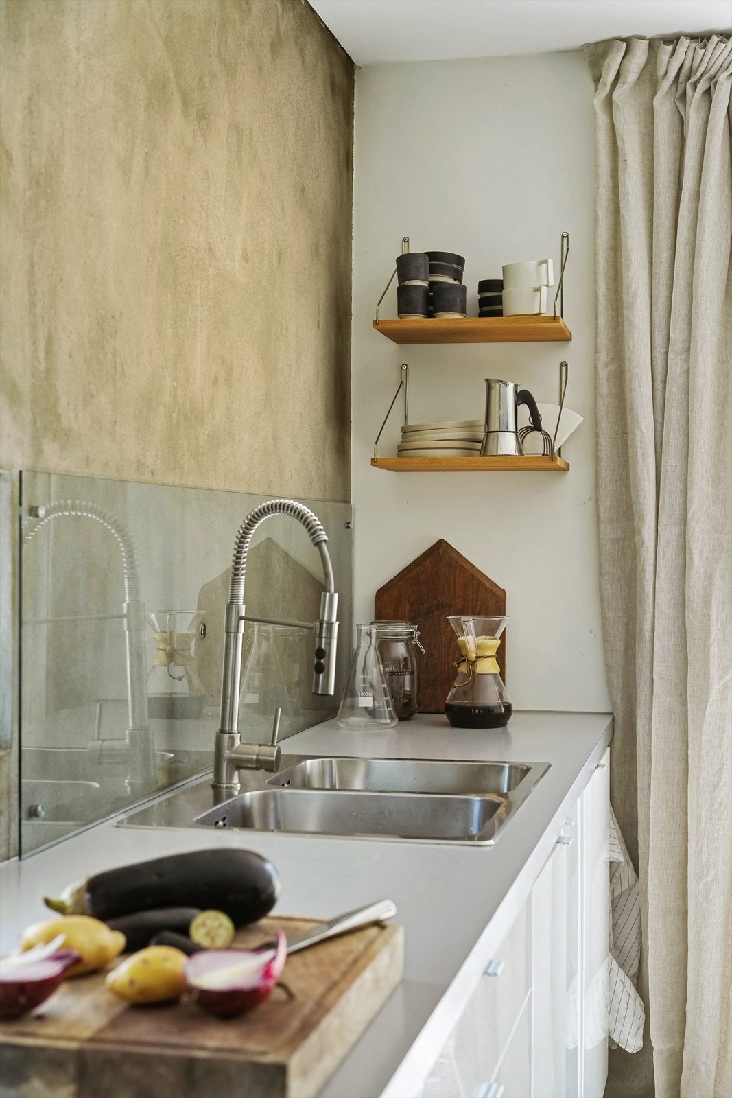 Det er montert glassplate på vegg bak nedfelt oppvaskkum Galleribilde