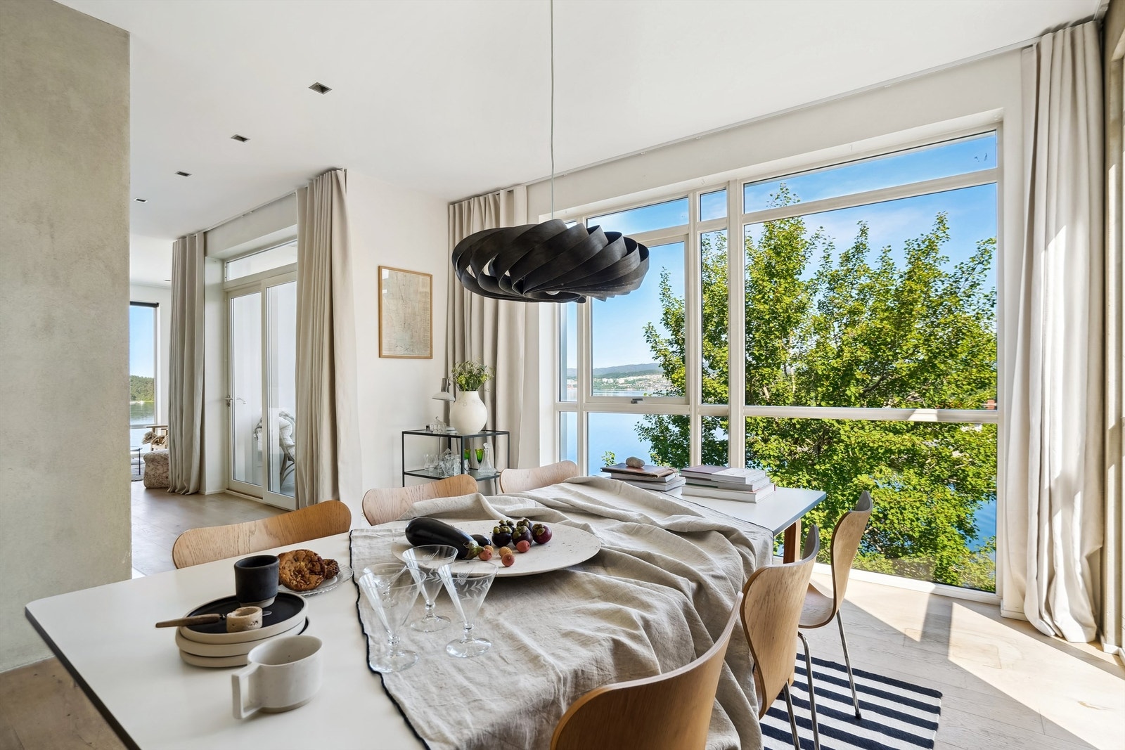 Spisestuen ligger i åpen løsning med stue og kjøkken, som til sammen danner et stilfullt og luftig uttrykk Galleribilde