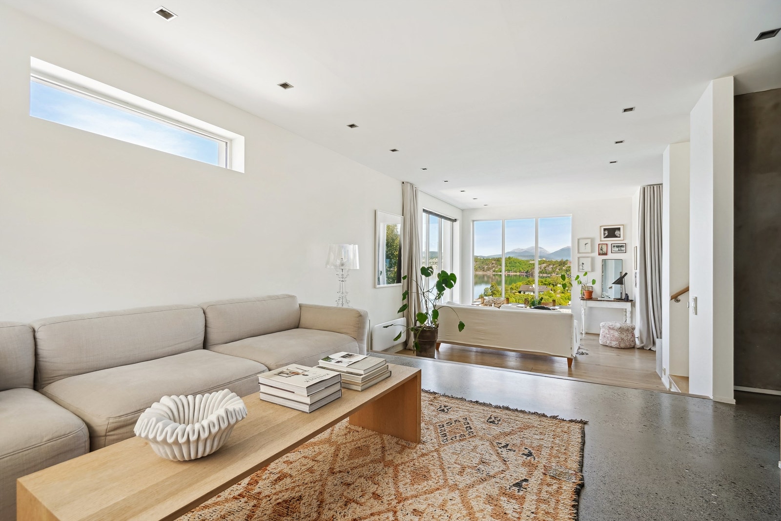 Fra tv-stuen mot stue med nivåforskjell mot stuen. Innfelte spotter i tak Galleribilde