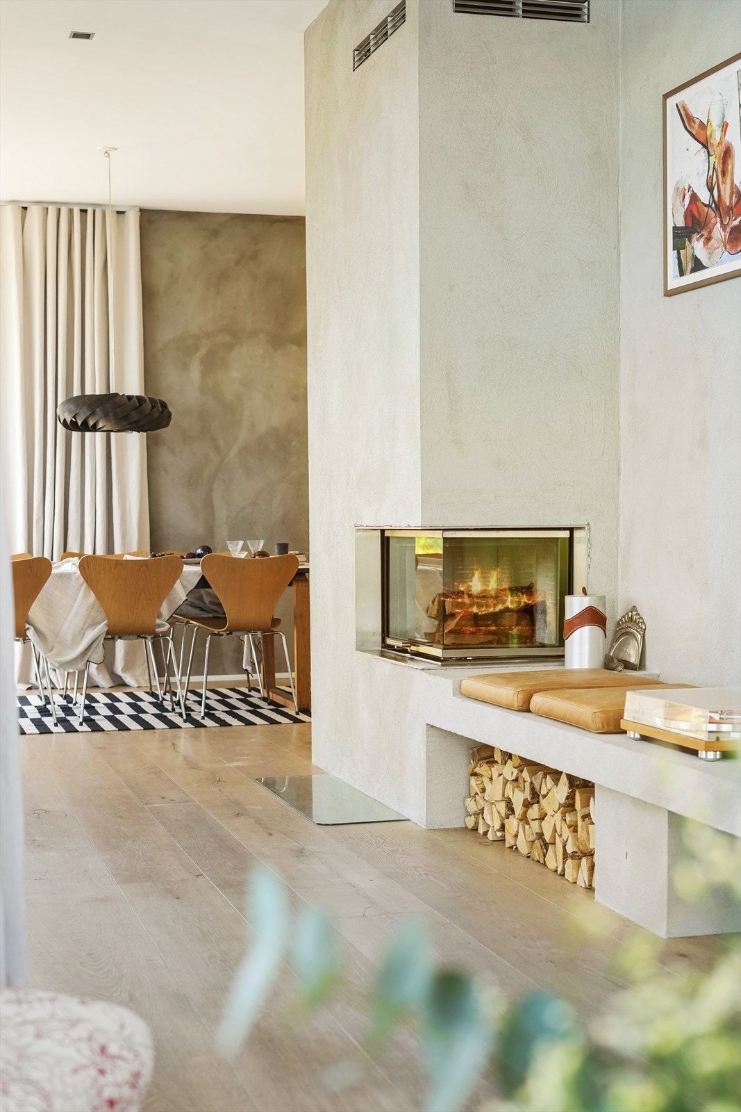 Murt peis i stuen med hyggelig sittebenk og oppbevaring av ved Galleribilde