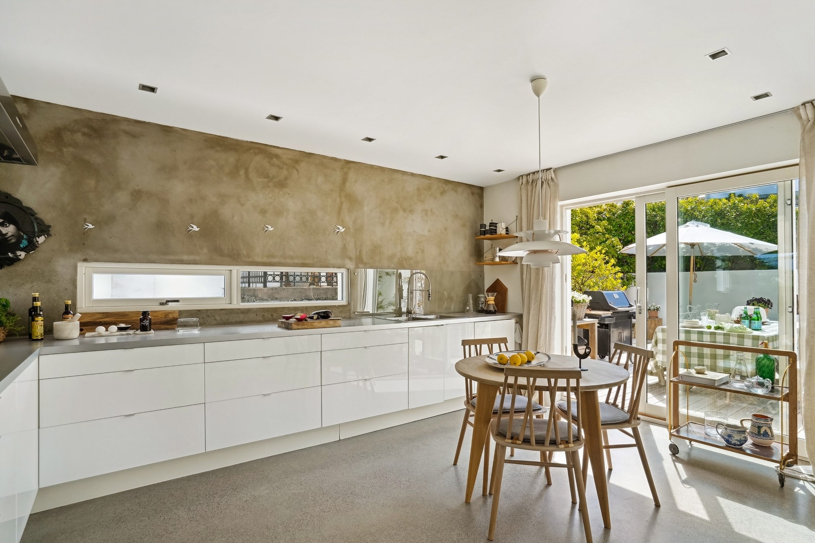 Det er godt med naturlig lys på kjøkkenet grunnet de store glassflatene i skyvedøren. Denne fører ut til terrassen med utepeis Galleribilde