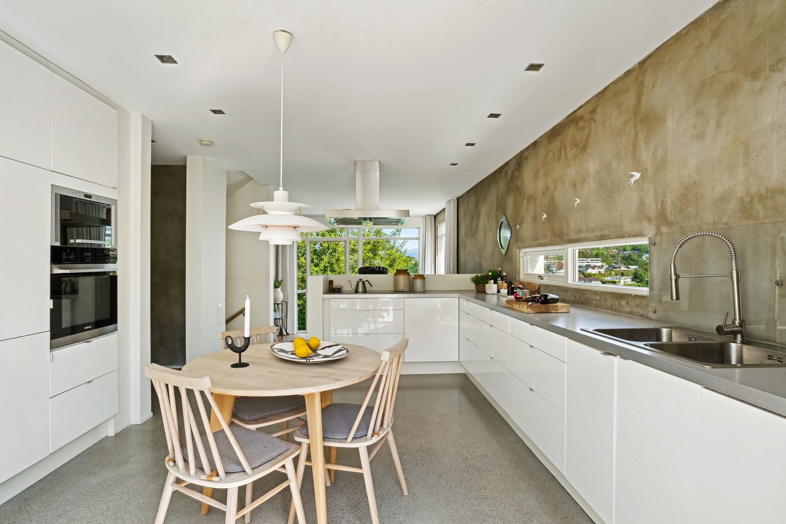 Veggene på kjøkkenet er delvis frie, noe som gir et rent og åpent uttrykk. Pusset murvegg mot øst og et åpningsvindu Galleribilde