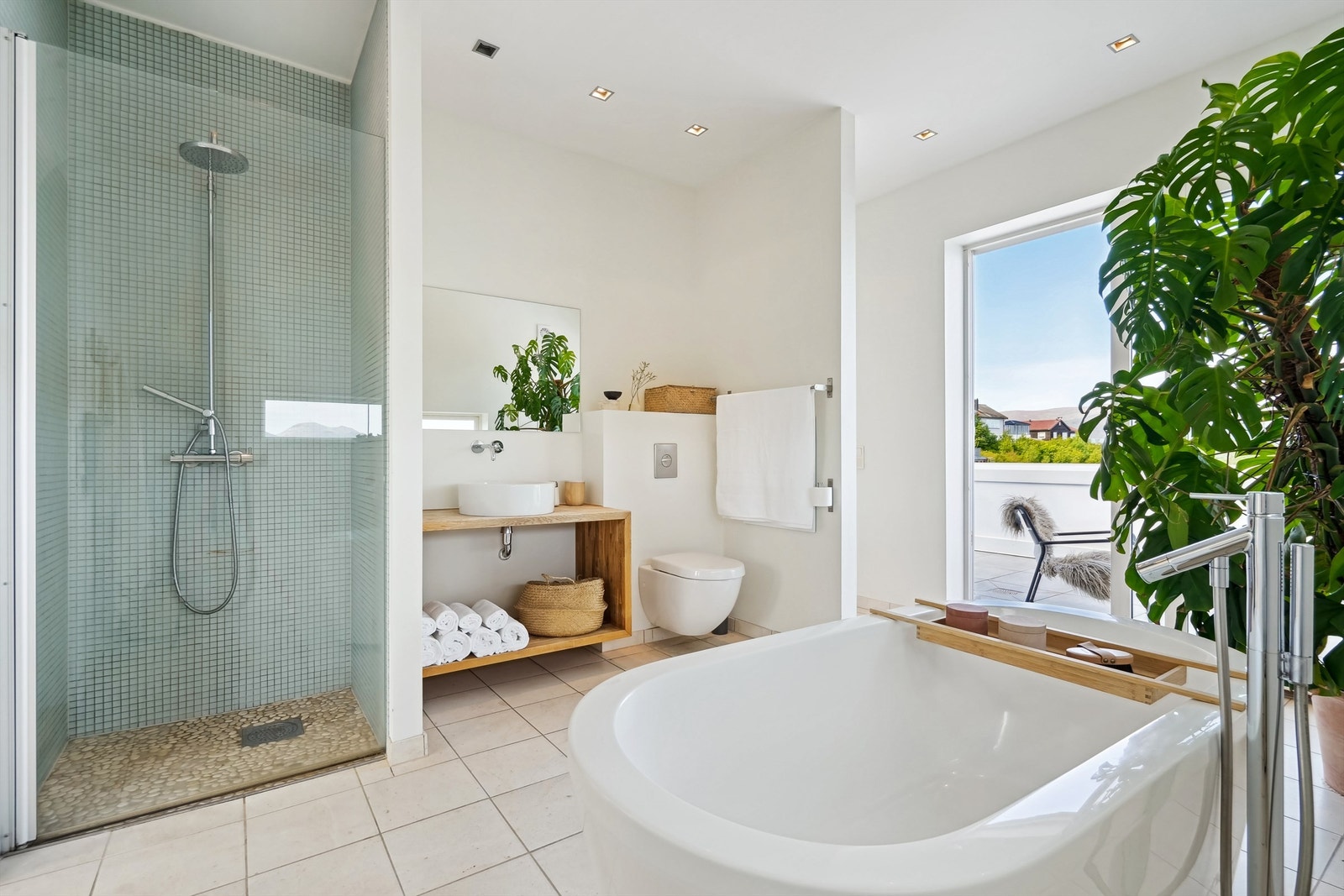 Bad i 2. etasje med innredning i heltre eik med ovenpåliggende servant og speil. Badekar, vegghengt wc og dusjnisje med glassdør, vegghengt dusjarmatur med hånddusj og regndusj Galleribilde