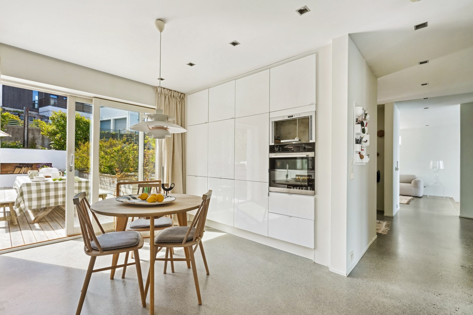 En hel vegg med høyskap fra gulv til tak med integrerte hvitevarer - en perfekt kombinasjon av funksjon og estetikk Galleribilde