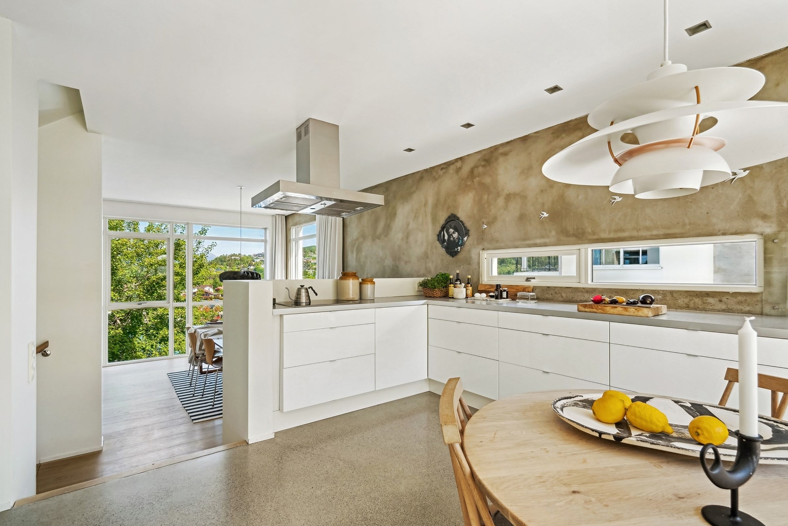 Hvit kjøkkeninnredning med glatte fronter og benkeplate av laminat. Nedfelt oppvaskkum med ett-greps kjøkkenarmatur. Mye benkeplass gir gode arbeidsmuligheter på kjøkkenet Galleribilde