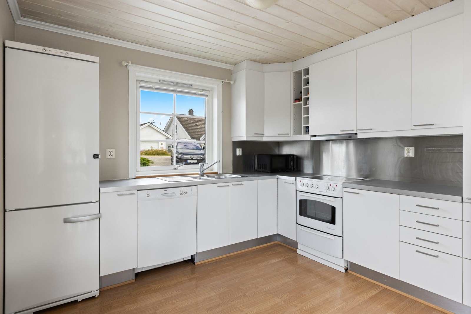 Kjøkkeninnredningen har en standard fra byggetiden, med fabrikk lakkerte overskap og underskap. Galleribilde