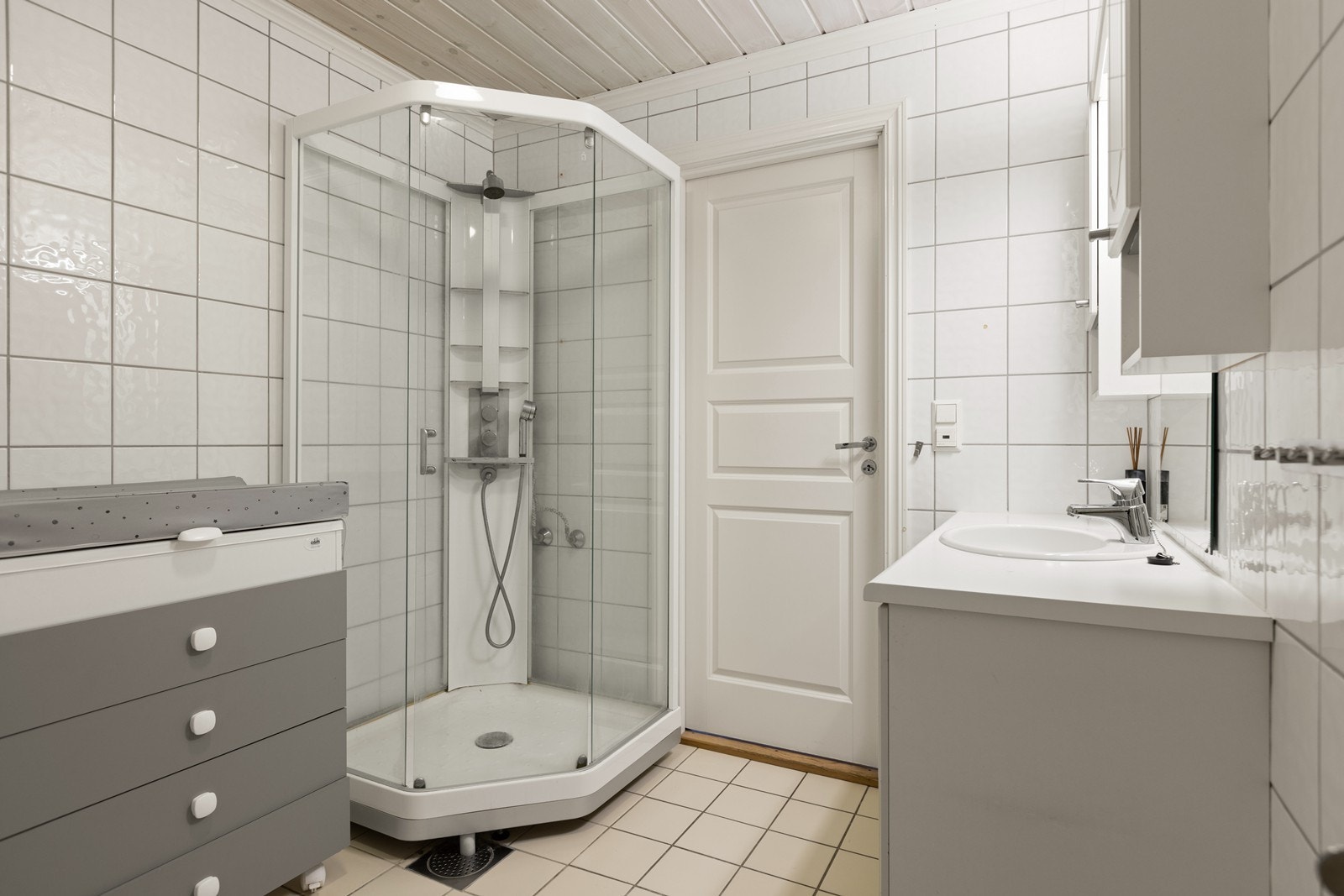 Det er flislagte vegger og gulv på badet. Rommet har dusjkabinett og varmekabler i gulvet. Galleribilde