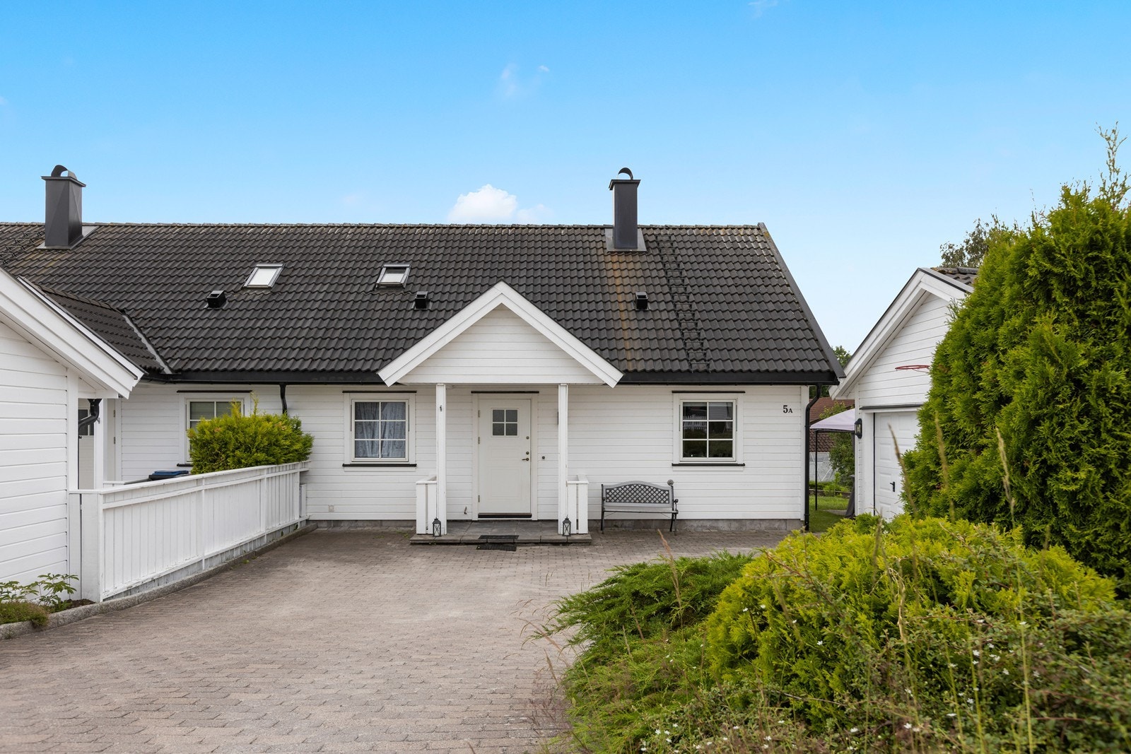 Boligen har overbygd inngangsparti og stor steinlagt gårdsplass. Galleribilde