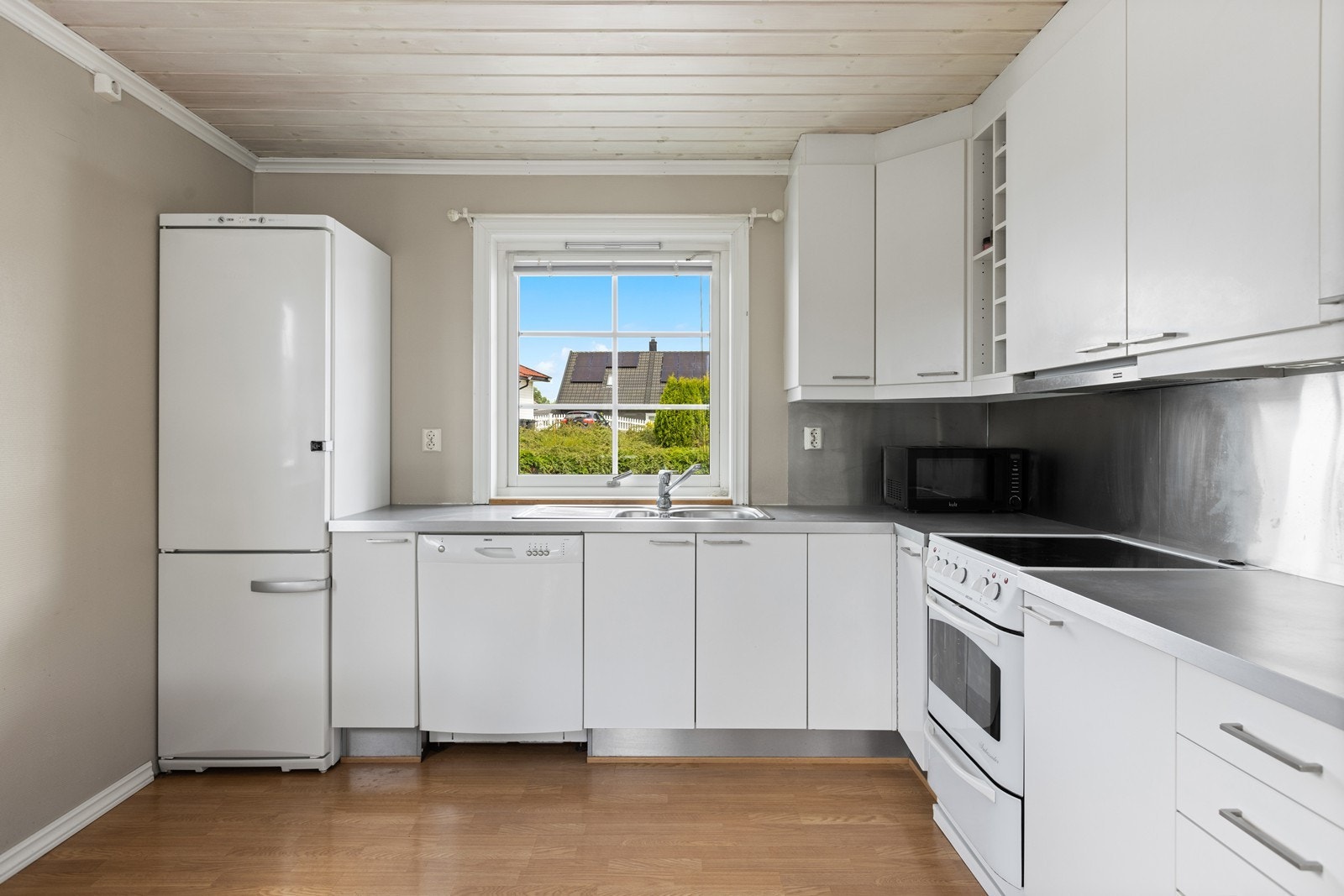 Hvitevarene på kjøkkenet er frittstående og det er laminat benkeplate. Her er det kjøkkenventilator med avtrekk ut. Galleribilde