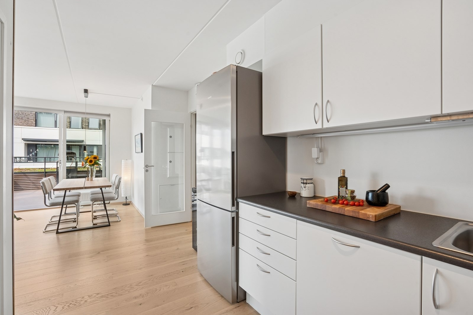 Kjøkkeninnredning består av hvite glatte fronter, benkeplate i laminat og rikelig med skapplass. Galleribilde